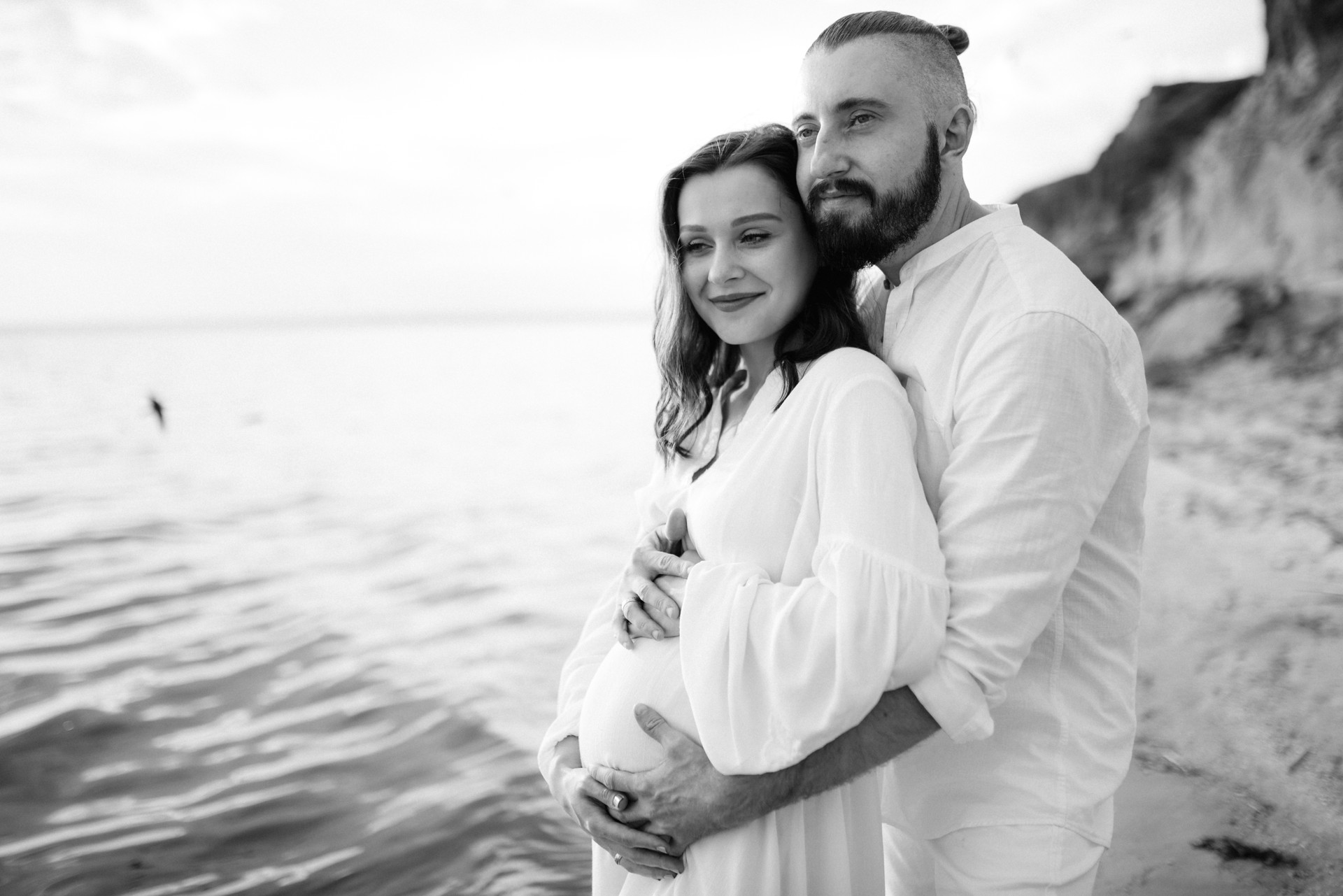 a guy with a girl in white clothes on the seashore